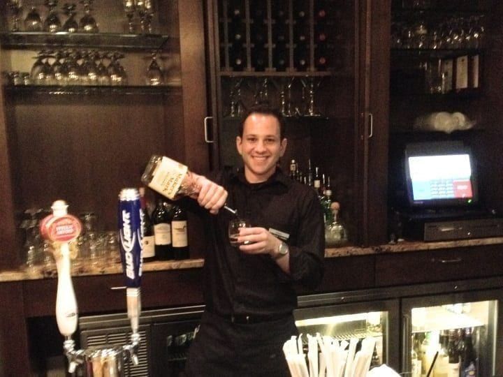 Working professional bartender pouring drinks
