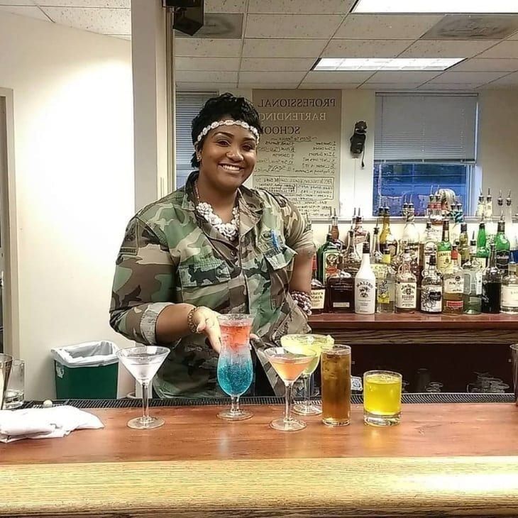 PBS student behind the bar with an array of finished cocktails